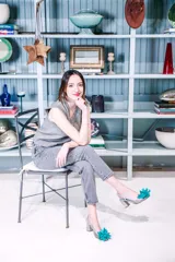 Zapato de tacón plateado con diseño de escamas y flor turquesa en la punta.