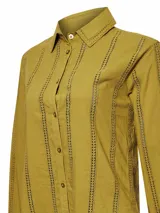 Blusa color crema de manga larga con cuello clásico y cierre frontal con botones. Presenta detalles de calado vertical en el frente y las mangas.