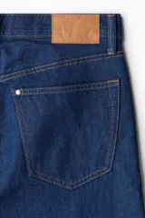 Pantalón de jean azul oscuro de corte recto y relajado, con cintura clásica y cinco bolsillos.