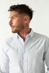 Camisa celeste a cuadros, de corte slim fit, manga larga y logo bordado. Confeccionada en 100% algodón.