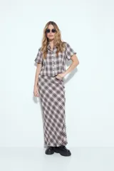 Falda larga de silueta fluida con estampado a cuadros en tonos marrones y beige. La prenda tiene una caída liviana y un calce cómodo.