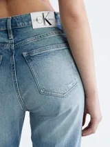 Jean de denim celeste con efecto desgastado y roturas, de corte mom, tiro alto y cinco bolsillos.