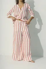 Pantalón palazzo de lino color blanco con rayas verticales rojas y cintura con cordón ajustable.