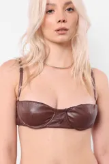 Top tipo brasier de cuerina elastizada color marrón, con aro media copa en busto, breteles regulables y acceso por espalda mediante lazo.