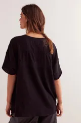 Remera negra de algodón con detalle de encaje en forma de V en el frente y mangas cortas.