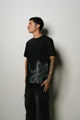 Remera negra de corte regular fit, confeccionada en jersey de algodón. Presenta un estampado plastisol de alta calidad en el frente.