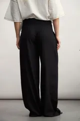 Pantalón de vestir verde militar, de corte palazzo, con pinzas en la cintura y bolsillos laterales.