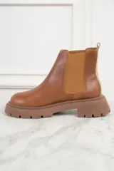 Bota Chelsea de cuero color marrón, con elásticos laterales y suela track.