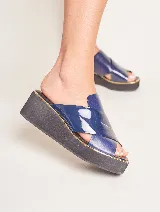 Sandalia de cuero azul con plataforma de goma negra y detalle de ribete dorado.