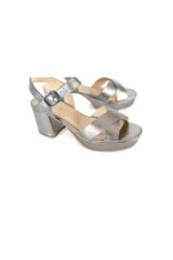Sandalias plateadas con plataforma y taco ancho, tiras cruzadas en el empeine y pulsera con hebilla al tobillo.