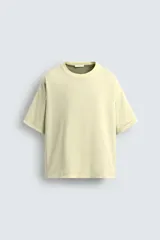 Camiseta color verde claro, de corte holgado, confeccionada en tejido de algodón con interior reversible de popelín. Tiene cuello redondo, manga corta y acabados con vivo combinado a contraste.