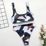 Conjunto de bikini con estampado animal en tonos marrón, negro y blanco. El top es de corte recto con tirantes anchos y la parte inferior es de corte clásico.