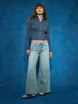 Campera azul de tejido de punto acanalado, con cuello alto, cierre frontal y mangas largas.