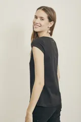 Remera negra ajustada al cuerpo, con detalles calados y escote en pico, confeccionada en algodón y elastano.