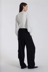 Pantalón negro de corte relajado, con bolsillos laterales y cintura elástica.