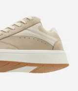 Championes casuales color beige, confeccionados en poliuretano con cordones y recortes.