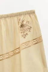Shorts color crema de tiro alto con cintura elástica, bordados florales y puntilla a tono.