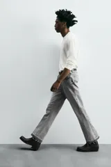 Pantalón de jean celeste de corte flare, con cinco bolsillos, efecto lavado y bajo con acabado irregular.
