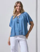 Blusa celeste de lyocell con escote en V, punto smock y lazo de ajuste.