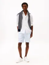 Camisa de lino blanco de manga larga con cuello clásico y cierre frontal de botones. Presenta un pequeño logo bordado de Tommy Hilfiger en el pecho.