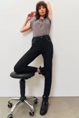 Pantalón jean negro de corte slim con detalles de tachas plateadas en los bolsillos delanteros y en el ruedo.