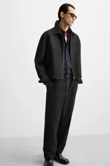 Pantalón negro de corte regular, confeccionado en tejido con viscosa, con cintura elástica, bolsillos frontales y trasero de vivo.