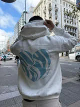 Canguro blanco de algodón con capucha, corte holgado y estampado en la espalda de un corazón celeste con patrón de cebra y la frase "very good".