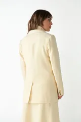 Blazer marrón de lana con solapas de muesca, cierre con dos botones dorados, bolsillos con solapa y forro interior a tono.