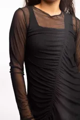 Minivestido negro de microtul elastizado, con mangas largas y drapeado frontal ajustable.