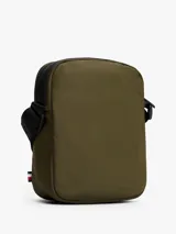 Cartera tipo reporter Tommy Hilfiger color verde militar con detalles en negro. Presenta correa ajustable, bolsillo frontal con cierre y logo metálico de la marca.