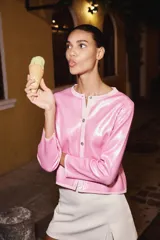 Chaqueta de lentejuelas rosa con cuello redondo, manga larga y cierre frontal con botones.