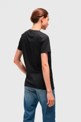 Remera negra con estampado de una mujer sentada en un sillón con un trago en la mano.