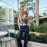 Chaleco corto color crema con escote en V, sisa redonda y cierre delantero con botones.