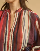 Blusa de algodón a rayas verticales rojas, marrones, blancas y negras, con cuello mao y escote en V.