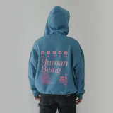 Canguro azul petróleo con capucha y bolsillo delantero, con logo 'Human Being' bordado en rosa en el pecho.