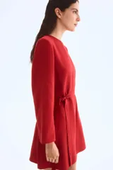 Vestido corto rojo de manga larga con escote redondo y cinturón fino para atar a la cintura.