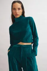 Pantalón de terciopelo azul marino, de corte sastrero amplio con pinzas, bolsillos laterales y largo al tobillo.