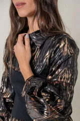 Blusa de satén con estampado animal print en tonos negro y tostado, con cintura elastizada y mangas amplias.
