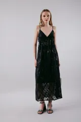 Vestido negro largo con detalles brillantes y tirantes finos, ideal para ocasiones elegantes.