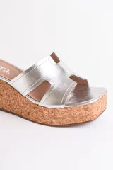 Sandalia dorada con plataforma de corcho y tiras cruzadas.