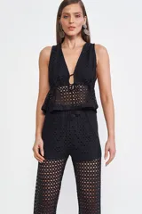 Blusa negra de crochet con escote en V y lazo ajustable en el centro.