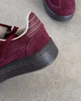 Zapatillas deportivas marrones de cuero vacuno con cordones y suela de goma.