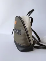 Mochila de cuero verde con detalles en blanco y negro.
