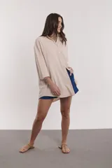 Camisa de algodón color beige, de corte suelto y con botones frontales.