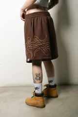 Bermuda marrón de algodón con corte oversize, cintura elástica con cordón ajustable y logo bordado en la pierna.
