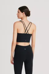 Top deportivo negro de cintura ancha, realizado en tela doble suave y de alta elasticidad. Detalle de breteles cruzados en la espalda.