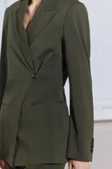 Blazer de Zara Woman Collection color verde musgo, de corte recto, con cuello solapa y manga larga. Tiene bolsillos de vivo en el delantero y cierre frontal cruzado con un botón.
