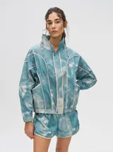 Campera rompevientos estilo biker con capucha desmontable, color celeste con estampado de nubes blancas y detalles en blanco.