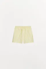 Bermuda corta tipo pijama con rayas verticales amarillas y blancas, tiro alto, cintura elástica ajustable con lazo y detalle de botones decorativos en el frente.