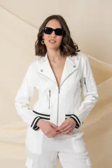 Chaqueta azul de cuero ecológico con cierre frontal asimétrico y cuello con solapas. Tiene puños elásticos a rayas blancas y azules, cierres metálicos plateados y un bolsillo en la manga.